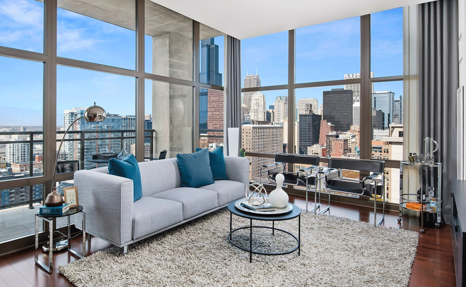 Living area of Astoria Tower apartment with floor to ceiling windows overlooking the south loop of Chicago