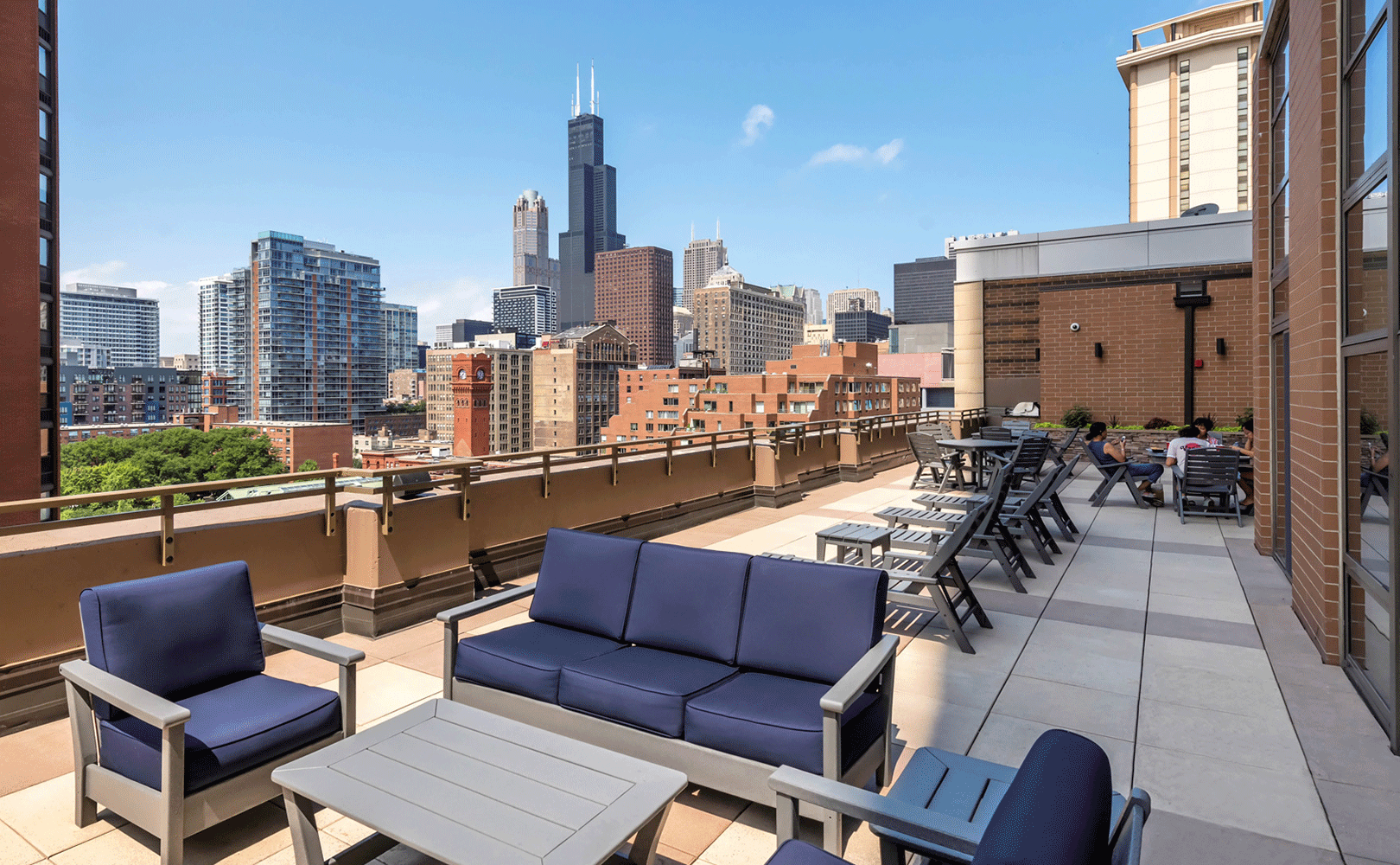Rooftop lounge with patio furniture and grilling station overlooking down town Chicago and the Sear's Tower